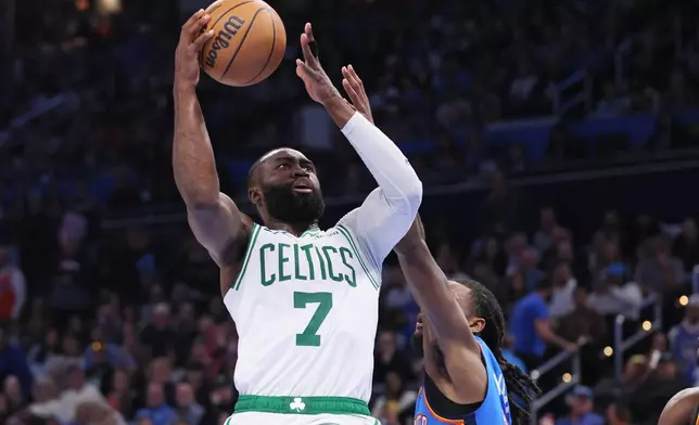 Boston Celtics guard Jaylen Brown takes the ball to the basket against Oklahoma City Thunder guard Cason Wallace, lower right, during the second half of an NBA basketball game, Thursday, March 12, 2026, in Oklahoma City. (AP Photo/Nate Billings)