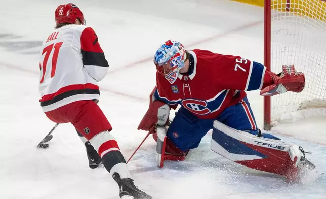 Montreal Canadiens goaltender Jakub Dobes (75) stops Carolina Hurricanes' Taylor Hall (71) on a breakaway during the first period of an NHL hockey game in Montreal on Tuesday, March 24, 2026. (Christinne Muschi/The Canadian Press via AP)