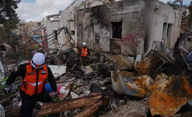 Israeli security forces survey the site that was struck by an Iranian missile in Dimona, southern Israel, Sunday, March 22, 2026. (AP Photo/Ariel Schalit)