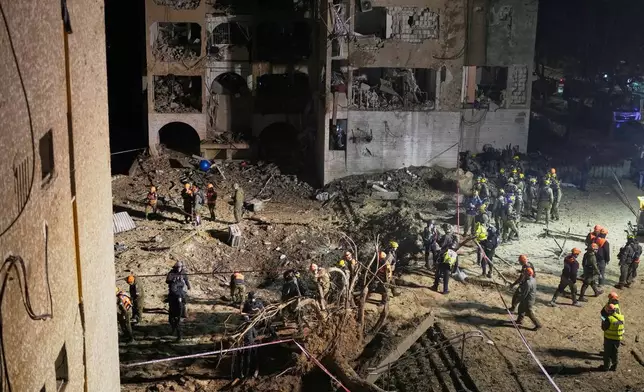 Israeli security forces and rescue teams work at the site struck by an Iranian missile in Arad, southern Israel, Sunday, March 22, 2026. (AP Photo/Ohad Zwigenberg)