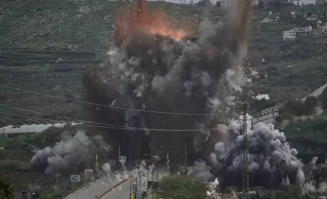 Smoke and flames rise from an Israeli airstrike that hit the Qasmiyeh Bridge near the coastal city of Tyre, Lebanon, Sunday, March 22, 2026. (AP Photo/Mohammad Zaatari)