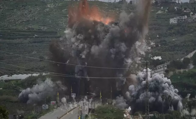 Smoke and flames rise from an Israeli airstrike that hit the Qasmiyeh Bridge near the coastal city of Tyre, Lebanon, Sunday, March 22, 2026. (AP Photo/Mohammad Zaatari)