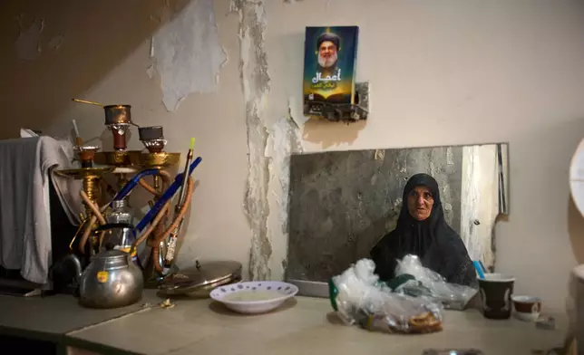 A woman displaced from Beirut's southern suburb of Haret Hreik is seen reflected in a mirror inside a hospital converted into a shelter in Beirut, Lebanon, Friday, March 27, 2026. (AP Photo/Emilio Morenatti)