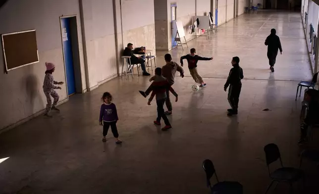 Displaced children from Beirut's southern suburbs play soccer inside a school converted into a shelter in Beirut, Lebanon, Friday, March 27, 2026. (AP Photo/Emilio Morenatti)