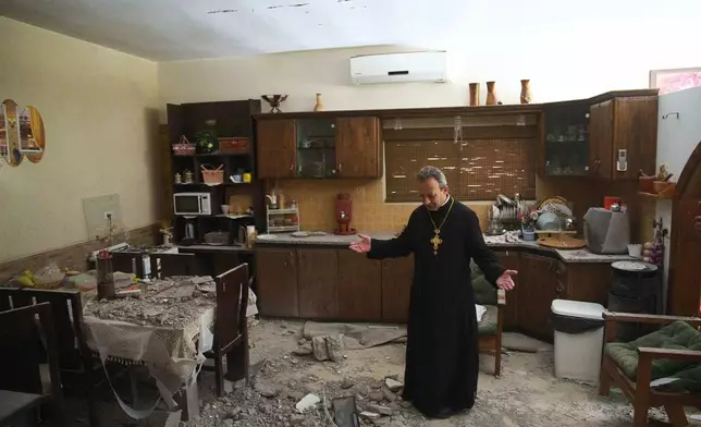 Monsignor Simon Khoury inspects a damaged house following an Iranian missile strike in Shefaram, Israel, Monday, March 30, 2026. (AP Photo/Ariel Schalit)