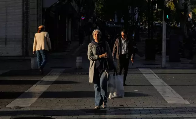 People cross an intersection in downtown Tehran, Iran, Monday, March 30, 2026. (AP Photo/Vahid Salemi)