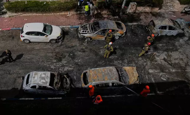 Israeli security forces and rescue teams inspect a site struck by an Iranian missile in Petah Tikva, Israel, Tuesday, March 31, 2026. (AP Photo/Ohad Zwigenberg)