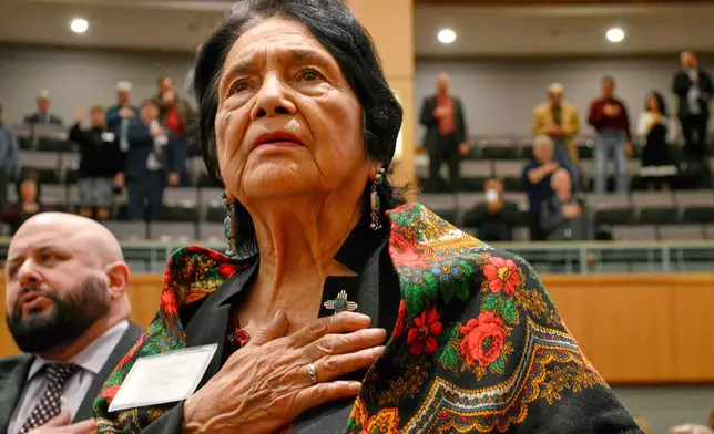 FILE - Dolores Huerta, the Mexican-American social activist who formed a farm workers union with Cesar Chavez, stands for the Pledge of Allegiance in Spanish while visiting the New Mexico Statehouse in Santa Fe. N.M., on Feb. 27, 2019. (AP Photo/Russell Contreras, File)