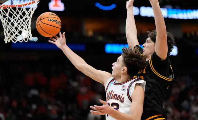 Illinois' Keaton Wagler, left, goes up for a shot as Iowa's Isaia Howard defends during the first half of an Elite Eight game in the NCAA college basketball tournament Saturday, March 28, 2026, in Houston. (AP Photo/Ashley Landis)