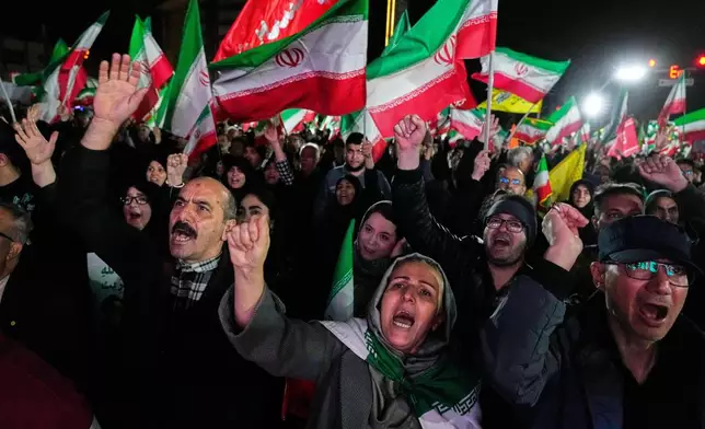 Pro-government supporters chant slogans and wave Iranian flags during a rally, in a square in western Tehran, Iran, Wednesday, March 25, 2026. (AP Photo/Vahid Salemi)