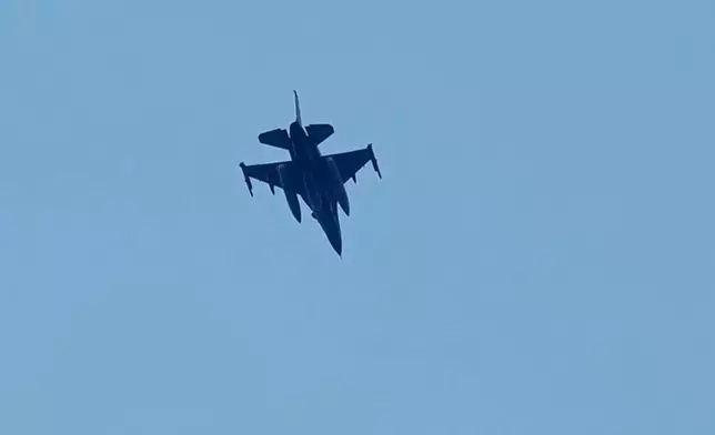 An Israeli warplane flies over the city of Tyre, south Lebanon, Wednesday, March 25, 2026. (AP Photo/Hussein Malla)