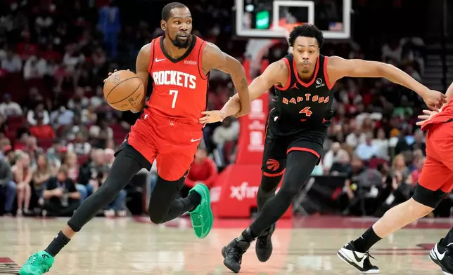 Houston Rockets forward Kevin Durant (7) dribbles as Toronto Raptors forward Scottie Barnes defends during the first half of an NBA basketball game Tuesday, March 10, 2026, in Houston. (AP Photo/Eric Christian Smith)