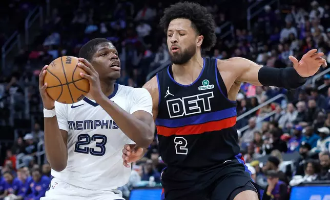 Memphis Grizzlies forward Cedric Coward (23) drives against Detroit Pistons guard Cade Cunningham (2) during the first half of an NBA basketball game Friday, March 13, 2026, in Detroit. (AP Photo/Duane Burleson)