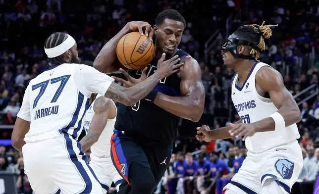 Detroit Pistons center Jalen Duren, center, drives to the basket against Memphis Grizzlies guards DeJon Jarreau (77) and Jahmai Mashack, right, during the second half of an NBA basketball game Friday, March 13, 2026, in Detroit. (AP Photo/Duane Burleson)