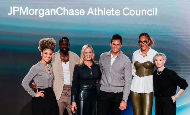Kristin Lemkau, CEO, J.P. Morgan Wealth Management, center left, poses for a picture with, from left, Ally Love, Peloton Instructor + VP, Instructor Strategy &amp; Development, Dwyane Wade, former NBA basketball player, Tom Brady, former NFL football player, A'ja Wilson WNBA basketblal player, and Meg Rapinoe, former women's soccer player, during a Pro Athlete event at JPMorganChase headquarters in New York, Wednesday, March 18, 2026. (AP Photo/Eduardo Munoz Alvarez)