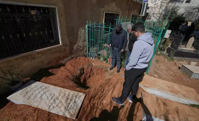 People look at the grave that was dug by Israeli forces landed late Friday, searching for Israeli co-pilot Ron Arad who was captured and then went missing after his fighter jet crashed over south Lebanon in 1986, in Nabi Chit village, eastern Lebanon, Sunday, March 8, 2026. (AP Photo/Bilal Hussein)
