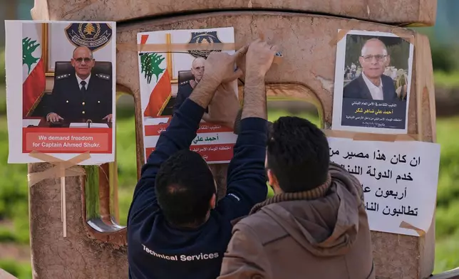 Family members of retired Lebanese officer Ahmed Shukr, hang posters of him during a gathering outside the headquarters of the U.N. Economic and Social Commission for Western Asia, ESCWA, in Beirut, Lebanon, Friday, Feb. 13, 2026. (AP Photo/Bilal Hussein)