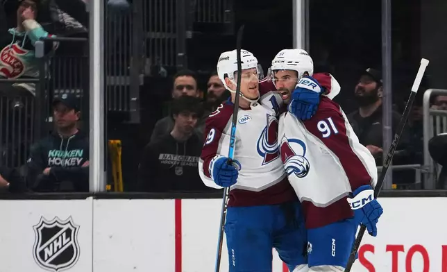 Colorado Avalanche center Nathan MacKinnon, left, greets center Nazem Kadri, right, after Kadri's goal against the Seattle Kraken during the second period of an NHL hockey game Thursday, March 12, 2026, in Seattle. (AP Photo/Lindsey Wasson)