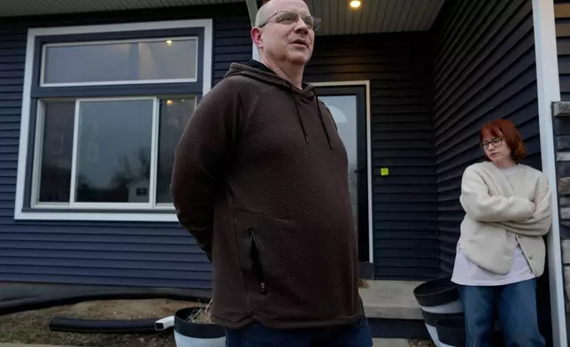 Andrew Coady and his daughter Keira, right, talk about his son, Sgt. Declan Coady, 20, of West Des Moines, Iowa, outside their home, Tuesday, March 3, 2026, in West Des Moines, Iowa. (AP Photo/Charlie Neibergall)