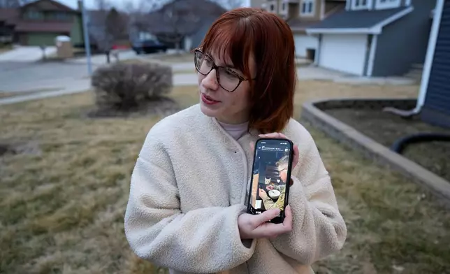 Keira Coady holds a photo of her brother, Sgt. Declan Coady, 20, of West Des Moines, Iowa, outside her home, Tuesday, March 3, 2026, in West Des Moines, Iowa. (AP Photo/Charlie Neibergall)