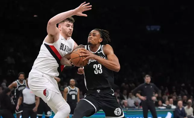 Portland Trail Blazers' Donovan Clingan (23) defends Brooklyn Nets' Nic Claxton (33) during the first half of an NBA basketball game Monday, March 16, 2026, in New York. (AP Photo/Frank Franklin II)