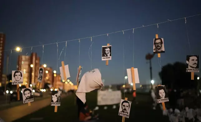 Photos of Uruguayans who disappeared in Argentina during Argentina's military dictatorship (1976–1983) are hung on a street in Montevideo, Uruguay, on the anniversary of the coup that brought the regime to power, Tuesday, March 24, 2026. (AP Photo/Matilde Campodonico)