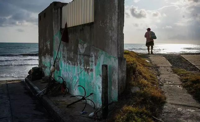 A fisherman stands on the shore after suspending fishing trips because of an oil spill in the Gulf of Mexico that authorities said originated from an unidentified vessel and two natural oil seeps, in Salinas, Mexico, Thursday, March 26, 2026. (AP Photo/Felix Marquez)