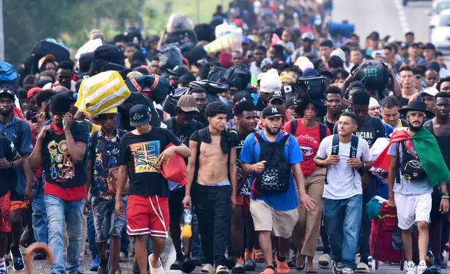Migrants walk on the highway through the municipality of Huehuetan, Chiapas state, Mexico, Wednesday, March 25, 2026, after leaving Tapachula the previous night. (AP Photo/Edgar H. Clemente)