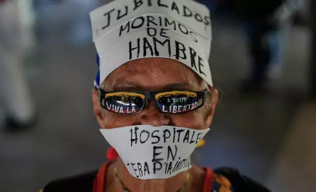A protester takes part in a march demanding higher salaries, pensions and benefits in Caracas, Venezuela, Wednesday, March 25, 2026. (AP Photo/Ariana Cubillos)