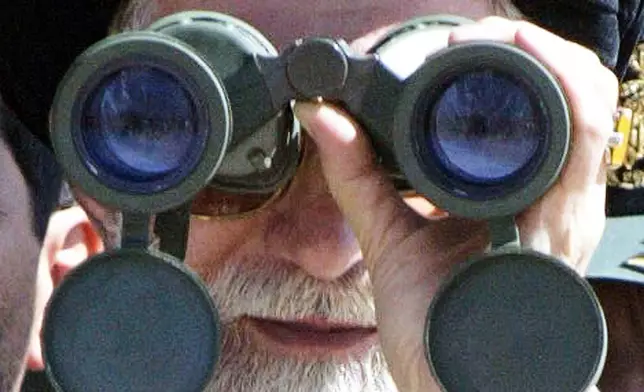 FILE - Iran's Supreme Leader Ayatollah Khamenei looks through binoculars during military manoeuvres by Iran's elite Revolutionary Guard, near the border with Iraq, Sept. 18, 2004. (AP Photo, File)