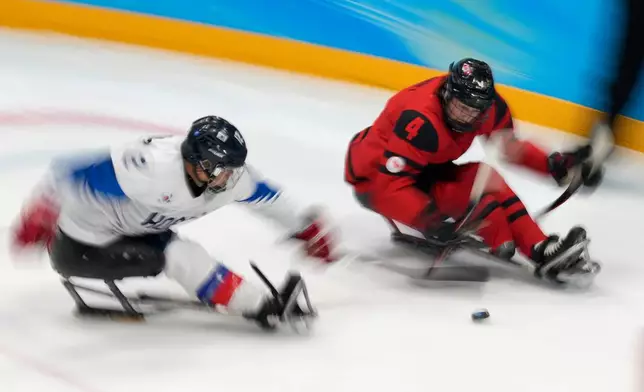 FILE - James Dunn of Canada battles for the puck against South Korea's Kim Young-sung during their para ice hockey semifinal match at the 2022 Winter Paralympics, Friday, March 11, 2022, in Beijing. (AP Photo/Dita Alangkara, file)