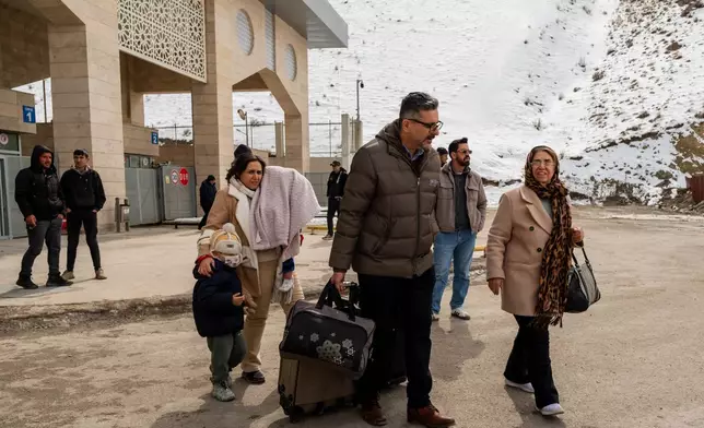 People, mostly Iranians who crossed from Iran at the Kapikoy border crossing, pull luggage in Turkey's eastern Van province, Friday, March 6, 2026. (AP Photo/Murat Kocabas)