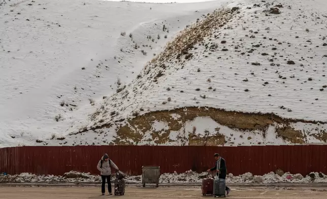 People, mostly Iranians who crossed from Iran through the Kapikoy border crossing, stand with luggage in Turkey's eastern Van province, Friday, March 6, 2026. (AP Photo/Murat Kocabas)