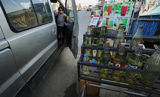 Gasoline bottles are displayed at a vendor's shop in Phnom Penh, Cambodia, Monday, March 30, 2026. (AP Photo/Heng Sinith)