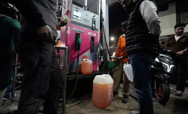 People store fuel in a plastic can at a petrol pump amid fears of a possible shortage due to the US Iran war, in Srinagar, Indian controlled Kashmir, Wednesday, March 25, 2026. (AP Photo/Mukhtar Khan)