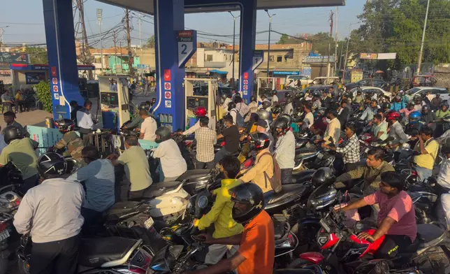Commuters wait in long queues for fuel at a petrol station in Prayagraj, India, Thursday, March 26, 2026, amid fears of shortages following the escalation of the U.S.-Israel-Iran conflict. (AP Photo/Rajesh Kumar Singh)