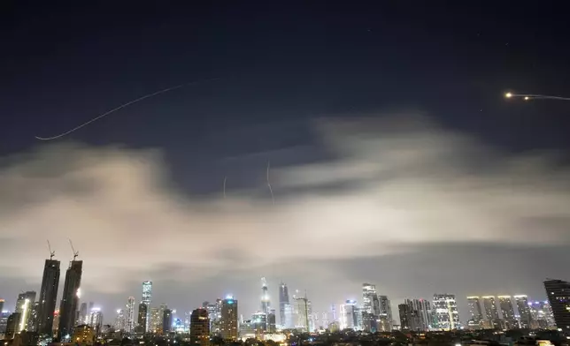 Israeli air defense system fires to intercept missiles during an Iranian attack over Tel Aviv, Israel, early Sunday, March 15, 2026. (AP Photo/Ohad Zwigenberg)