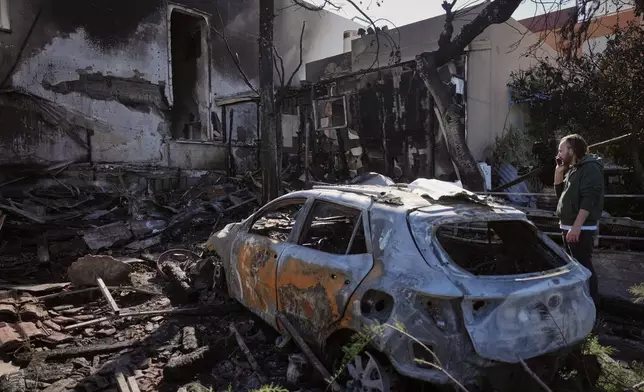 Residents inspect a house damaged yesterday by a projectiles launched from Lebanon in Nahariya, northern Israel, Tuesday, March 17, 2026. (AP Photo/Ariel Schalit)