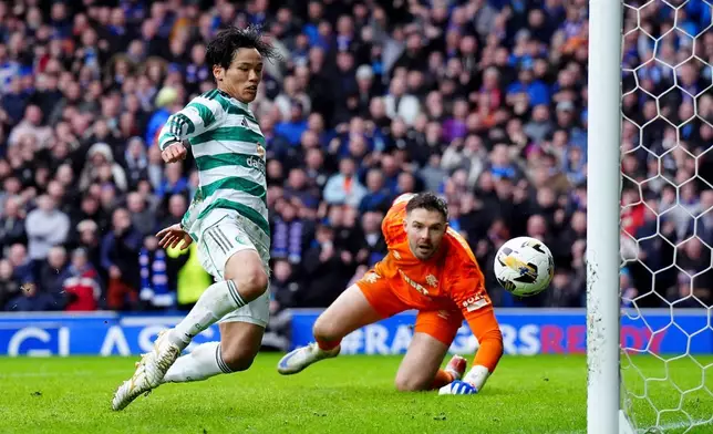 Celtic's Reo Hatate, left, scores his side's second goal during the Scottish Premiership match between Glasgow Rangers and Celtic Glasgow in Glasgow, Scotland, Sunday, March 1, 2026. (Steve Welsh/PA via AP)