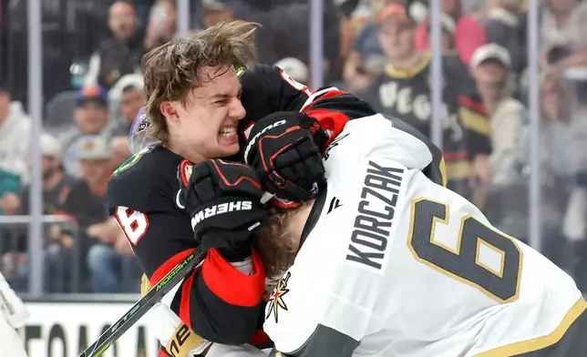 Chicago Blackhawks center Connor Bedard (98) fights with Vegas Golden Knights defenseman Kaedan Korczak (6) during the first period of an NHL hockey game Saturday, March 14, 2026, in Las Vegas. (AP Photo/Steve Marcus)