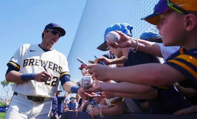 Milwaukee Brewers' Christian Yelich signs autographs prior to a spring training baseball game against the Los Angeles Dodgers Monday, March 9, 2026, in Phoenix. (AP Photo/Ross D. Franklin)