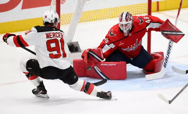 Washington Capitals goaltender Logan Thompson (48) stops the puck shot by New Jersey Devils center Dawson Mercer (91) during the third period of an NHL hockey game Friday, March 20, 2026, in Washington. (AP Photo/Nick Wass)