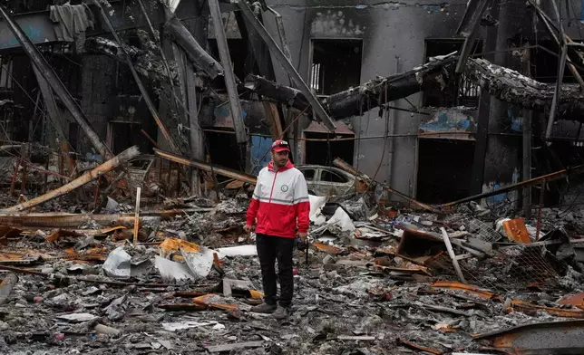 A member of the Iranian Red Crescent Society stands at Hypercar, an auto service center, amid damages which according to the company's officials were caused by strikes on March 1, in Tehran, Iran, Saturday, March 28, 2026. (AP Photo/Vahid Salemi)