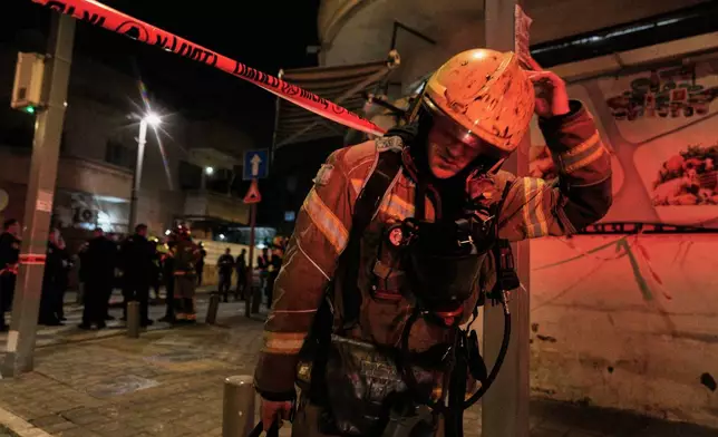 An Israeli first responder walks from the site of a missile strike in Tel Aviv, Israel, early Saturday, March 28, 2026. (AP Photo/Maya Levin)