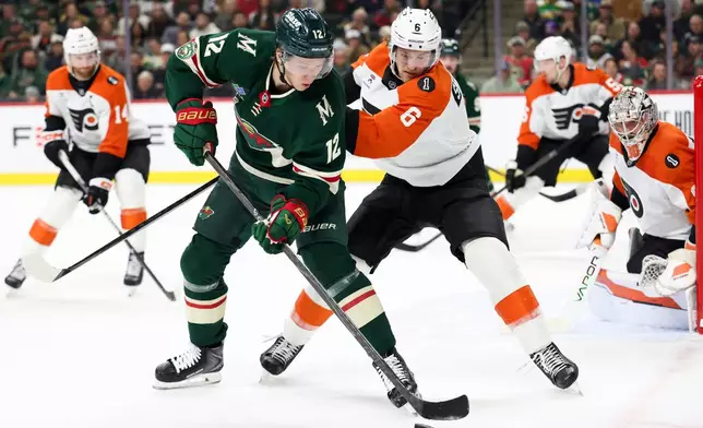 Minnesota Wild left wing Matt Boldy (12) handles the puck against Philadelphia Flyers defenseman Travis Sanheim (6) during the first period of an NHL hockey game Thursday, March 12, 2026, in St. Paul, Minn. (AP Photo/Ellen Schmidt)