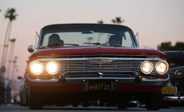 Lowriders cruise at the 6th Annual Lady Lowrider Cruise Night in celebration of International Women's Day in Pasadena, Calif., on Sunday, March 8, 2026. (AP Photo/Damian Dovarganes)