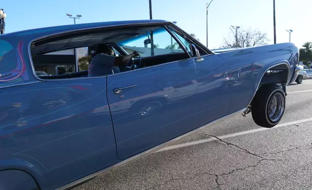 Tina L. Blankenship-Early rides her 1966 Chevrolet Caprice "Game Killa" at the 6th Annual Lady Lowrider Cruise Night in celebration of International Women's Day in Pasadena, Calif., on Sunday, March 8, 2026. (AP Photo/Damian Dovarganes)