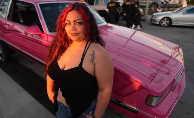 Amber, a low rider, poses for a portrait at the 6th Annual Lady Lowrider Cruise Night in celebration of International Women's Day in Pasadena, Calif., on Sunday, March 8, 2026. (AP Photo/Damian Dovarganes)