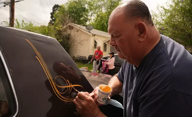 Freehand and pinstriping artist Danny Alvarado works on a lowrider at his workshop in Monrovia, Calif., Tuesday, March 10, 2026. (AP Photo/Damian Dovarganes)