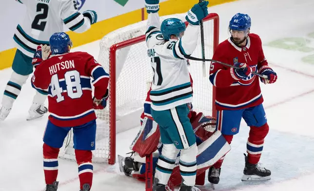 San Jose Sharks' Collin Graf (51) celebrates his goal in front of Montreal Canadiens goaltender Jakub Dobes (75), Lane Hutson (48) and Alexandre Carrier (45) during second period NHL hockey action in Montreal on Saturday, March 14, 2026. (Christinne Muschi/The Canadian Press via AP)